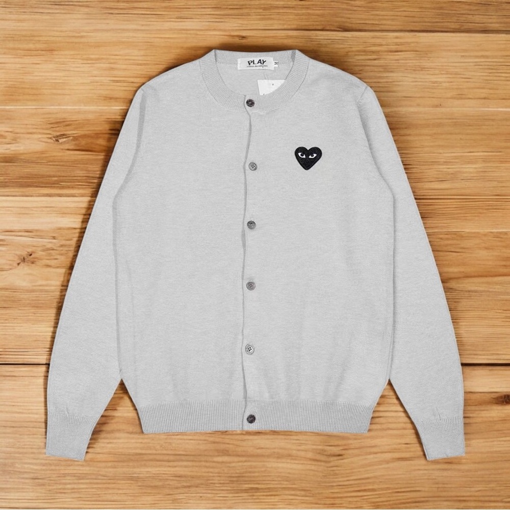 Comme des Garcons PLAY grey cardigan with heart-shaped embellishments.